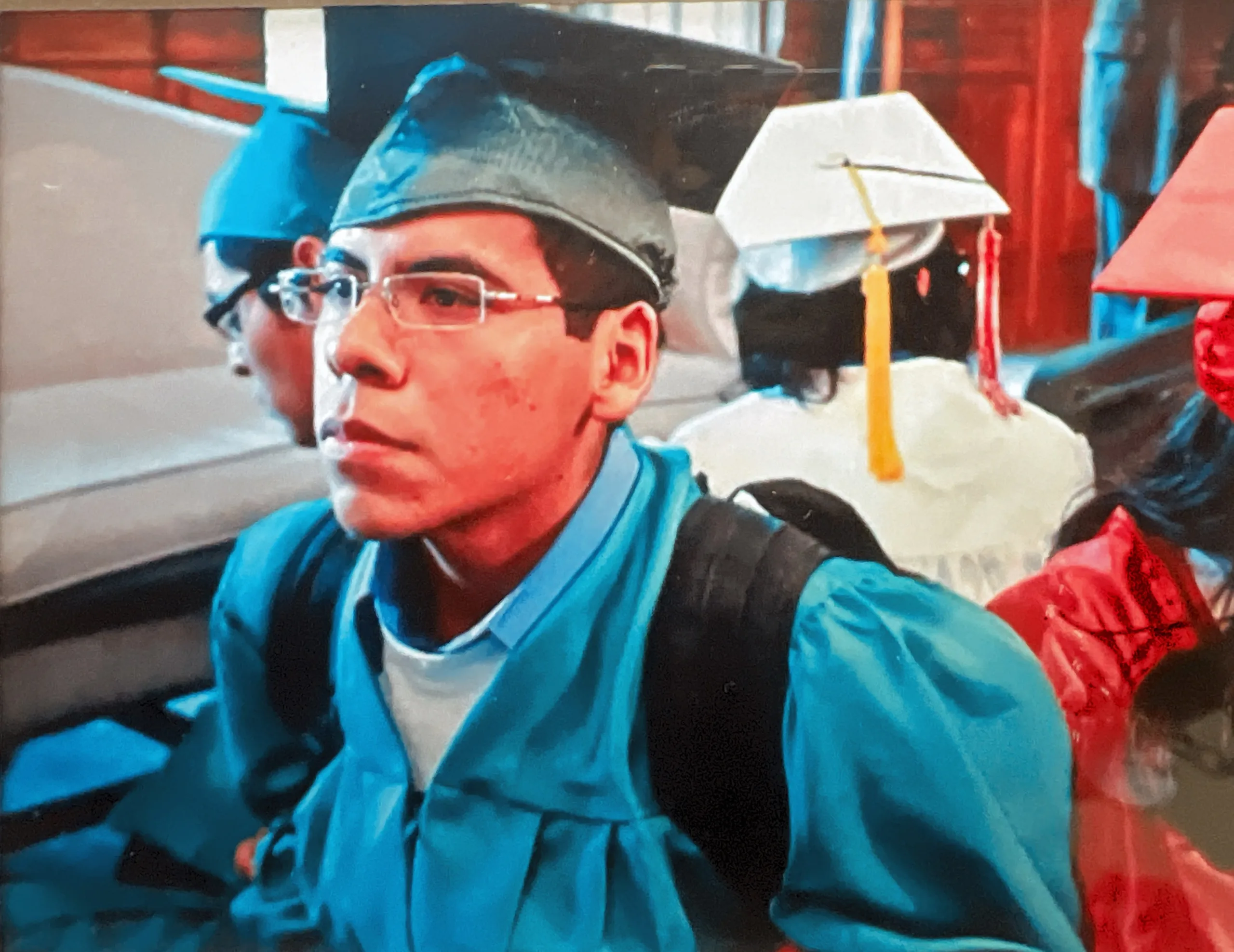 Omar and Eric Gama at the Statehouse in their high school graduation caps and gowns/