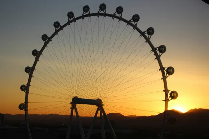 An observation-style ferris wheel, with a sunrise in the background
